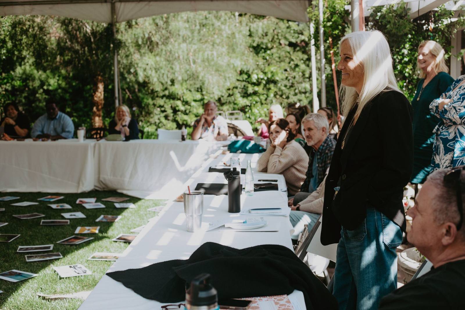 Leaders in discussion around a table during an outdoor cohort session